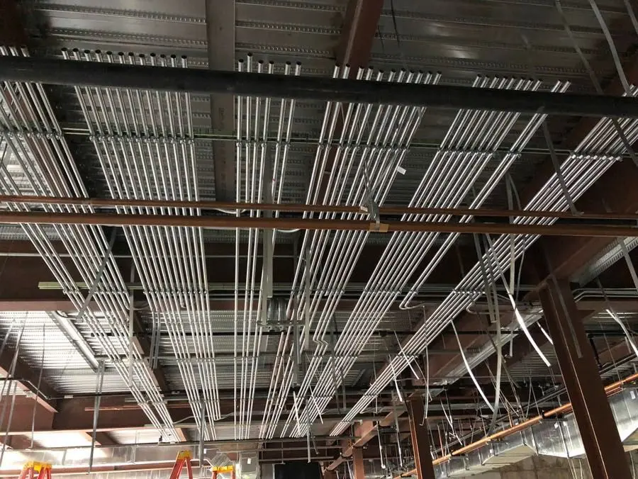 A ceiling with many wires hanging from it.