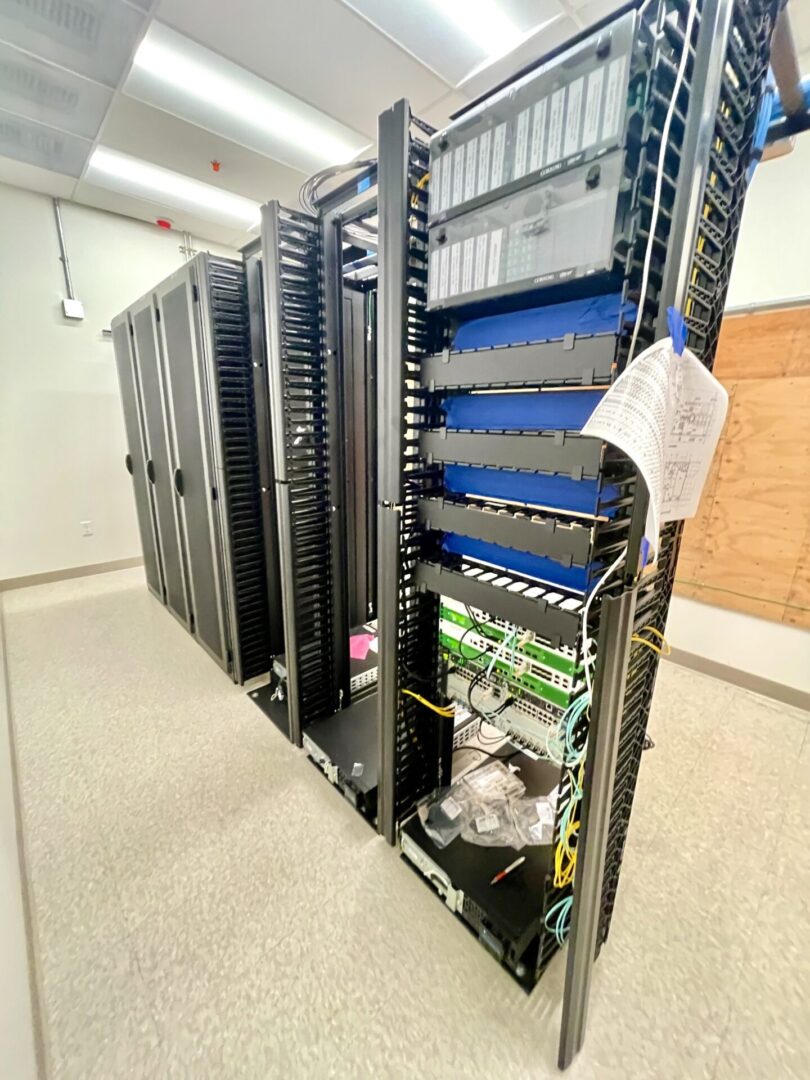 A rack of computers in a room with a door.